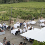 Wine tasting setup at Podere Ema with glasses of red and white wine overlooking the vineyards.