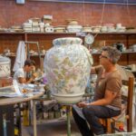 Artisan decorating a large ceramic vase during the Montelupo factory tour