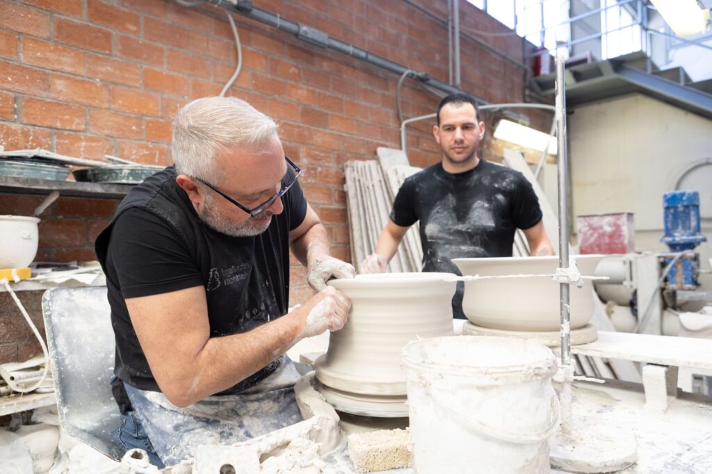 Master artisan demonstrating traditional technique during the pottery wheel workshop in Tuscany