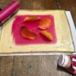 Autumn leaves arranged on a pink acrylic gel plate at a kids art class Florence, Fatacadabra