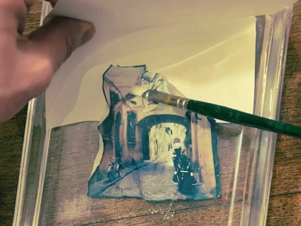 Polaroid emulsion being shaped onto watercolor paper during a hands-on photography Florence session at Fatacadabra