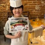 Family cooking class Florence guest showing handmade pasta and cooking class certificate
