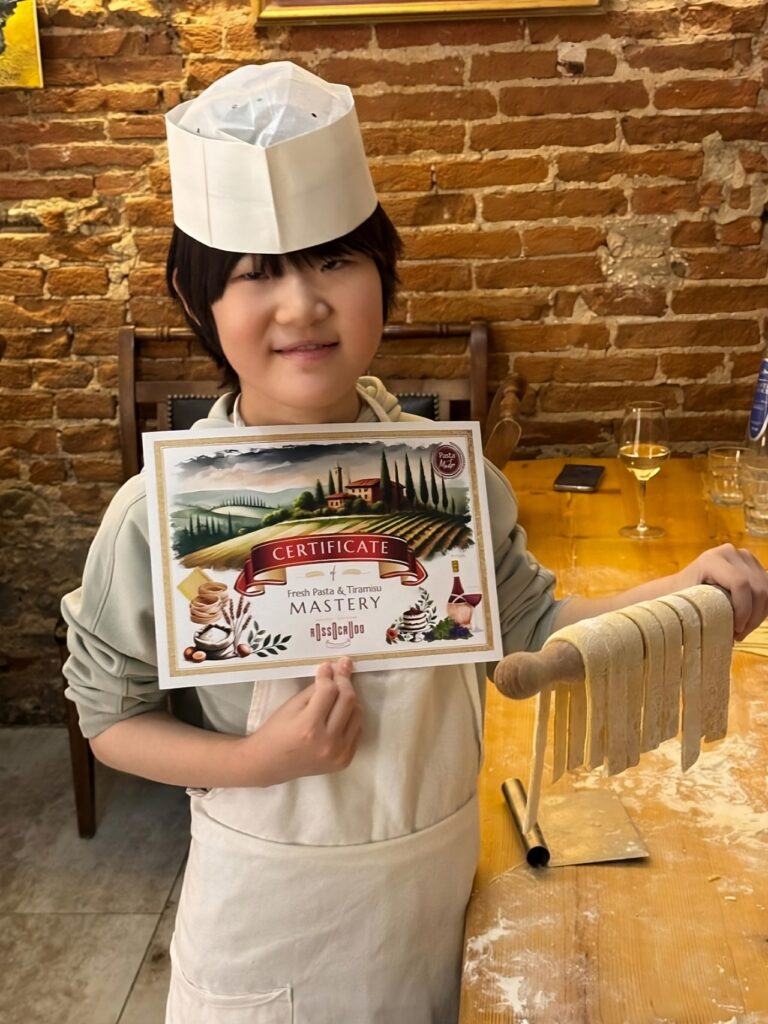 Family cooking class Florence guest showing handmade pasta and cooking class certificate