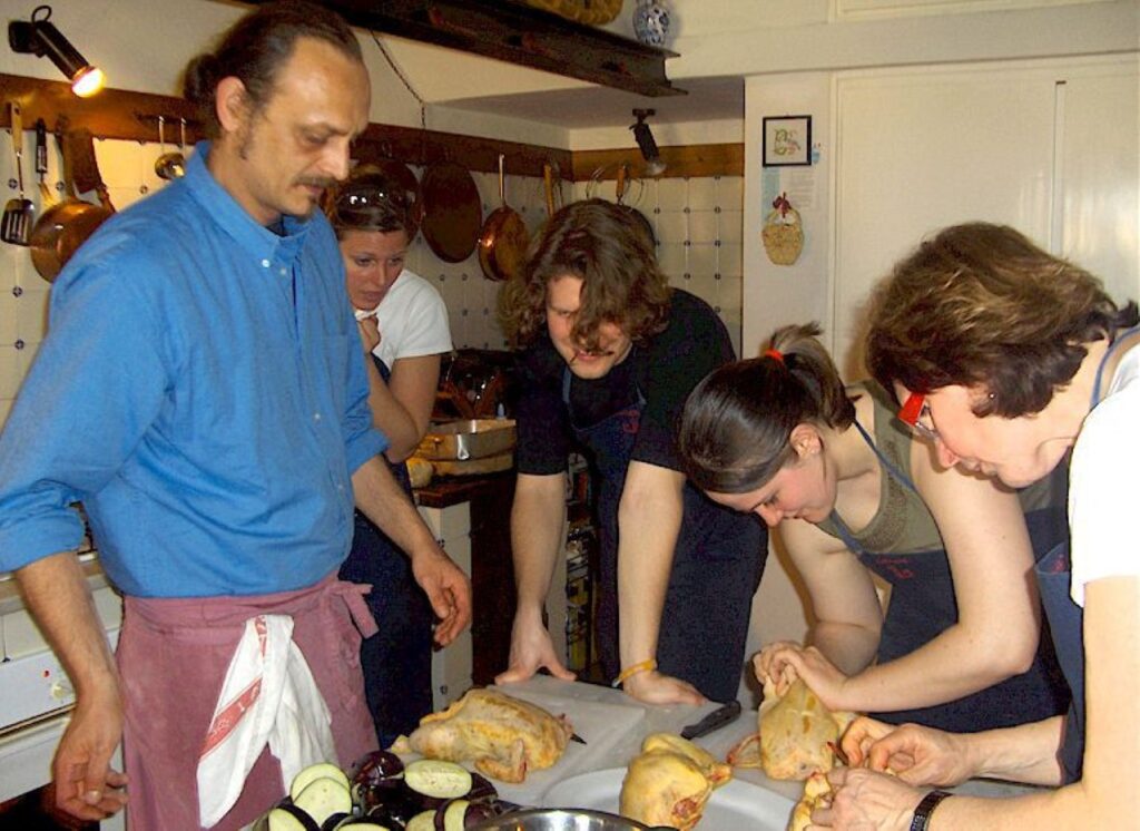 Chef and guests preparing meat together during a private tuscan farmhouse cooking class