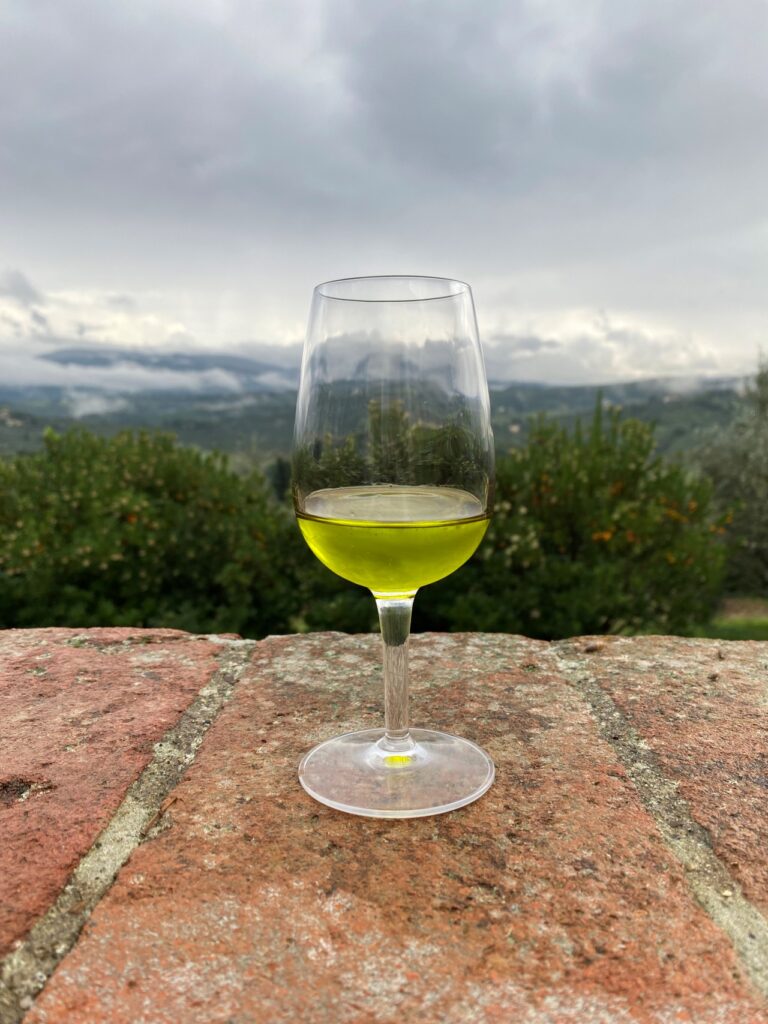 Chianti cooking class with olive oil tasting featuring a glass of fresh extra virgin olive oil overlooking the Chianti hills