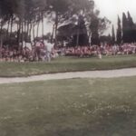 Crowd watching a golf tournament near a green at a historic Chianti club.