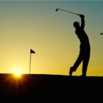 Golfer silhouette at sunset on a Tuscan course during a chianti golf lunch tour from Florence.