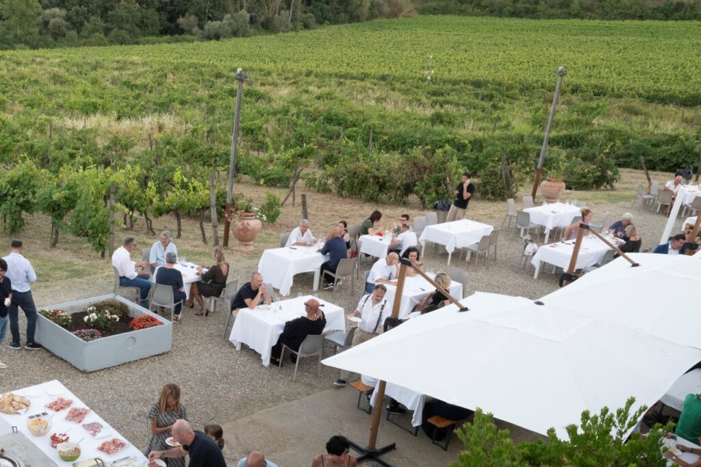 Outdoor Tuscan lunch setup on a winery terrace overlooking Chianti vineyards