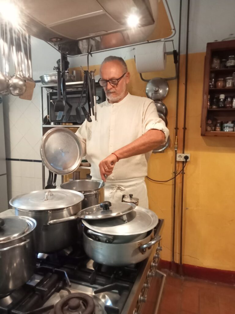 Chef stirring a pot at the stove during a private cooking class in Florence.