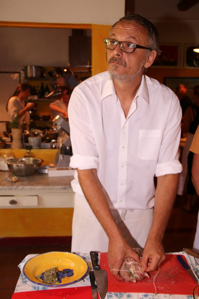 Chef preparing and tying a roast on a worktable during a private cooking class in Florence.