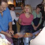 Chef preparing tomato sauce while guests watch during a hands-on cooking in Florence.