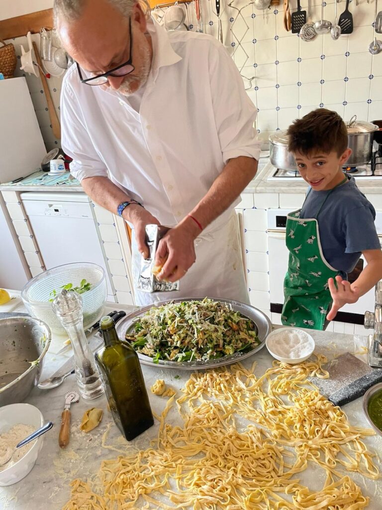 Chef and child finishing a fresh pasta dish during a family-friendly cooking class in Florence.