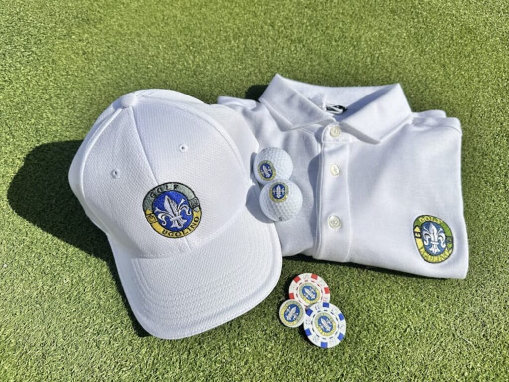 Golf Club Ugolino branded cap, polo shirt, and golf balls on green turf