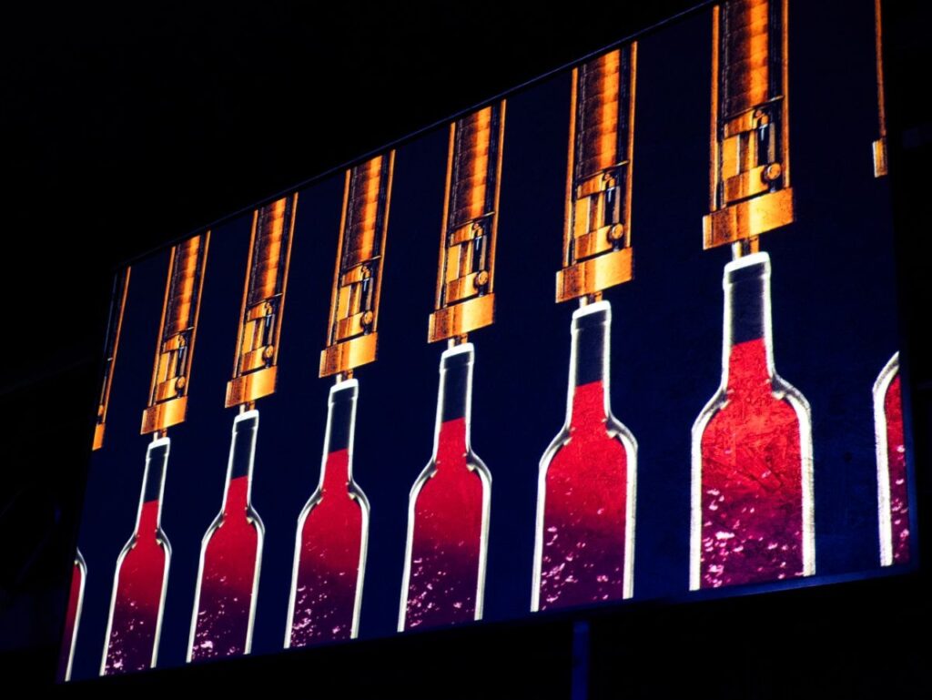 Artistic wine bottle light installation inside the immersive winery experience.