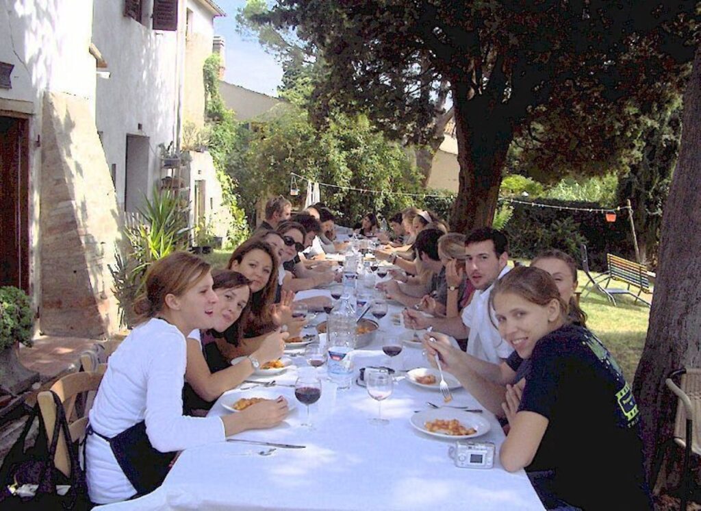 Guests enjoying an outdoor meal in the farmhouse garden after a Tuscan countryside cooking class.