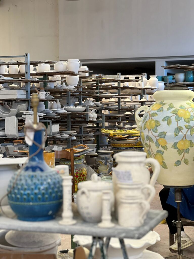 Studio shelves with pottery and materials inside the Montelupo ceramics workshop