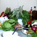 Fresh vegetables, herbs, olive oil, and local products prepared for a Tuscan countryside cooking class.