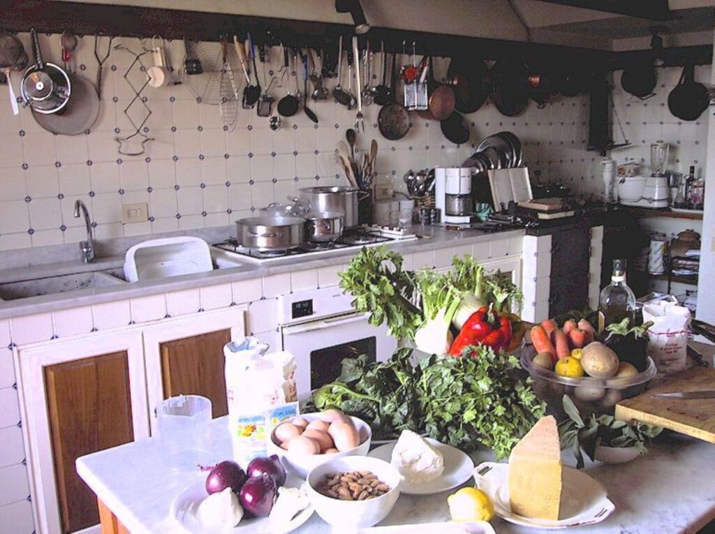 Traditional Tuscan farmhouse kitchen set for a private cooking class with fresh seasonal ingredients on the counter.
