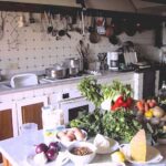 Traditional Tuscan farmhouse kitchen set for a private cooking class with fresh seasonal ingredients on the counter.