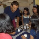 chef teaching children how to cut dough during a cooking class