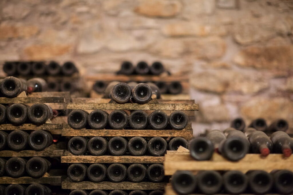 bottles aging in traditional Chianti wine cellar in Tuscany