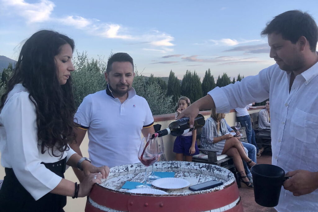 pouring red wine during Chianti wine tasting on countryside terrace