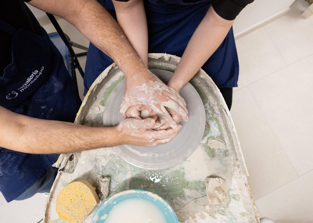 Guided wheel shaping during the pottery wheel workshop in Tuscany