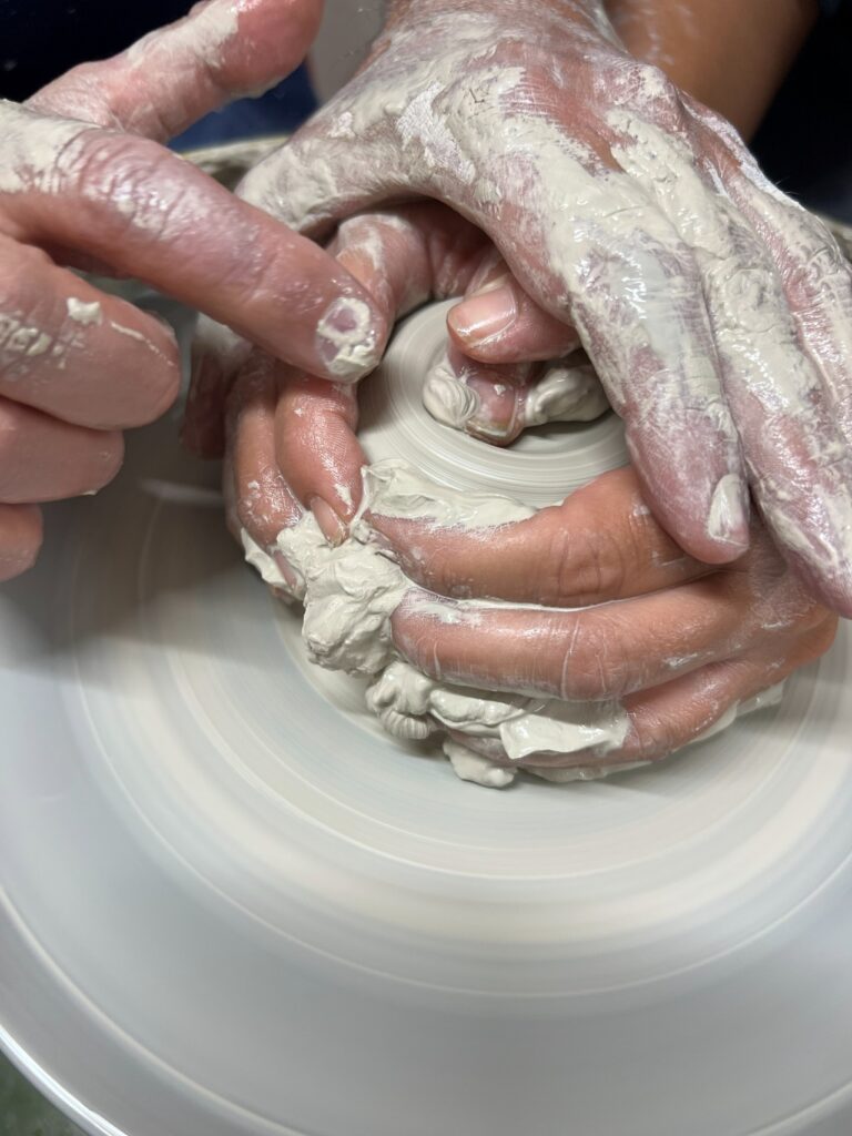 Close-up of guided technique during the pottery wheel class near Florence