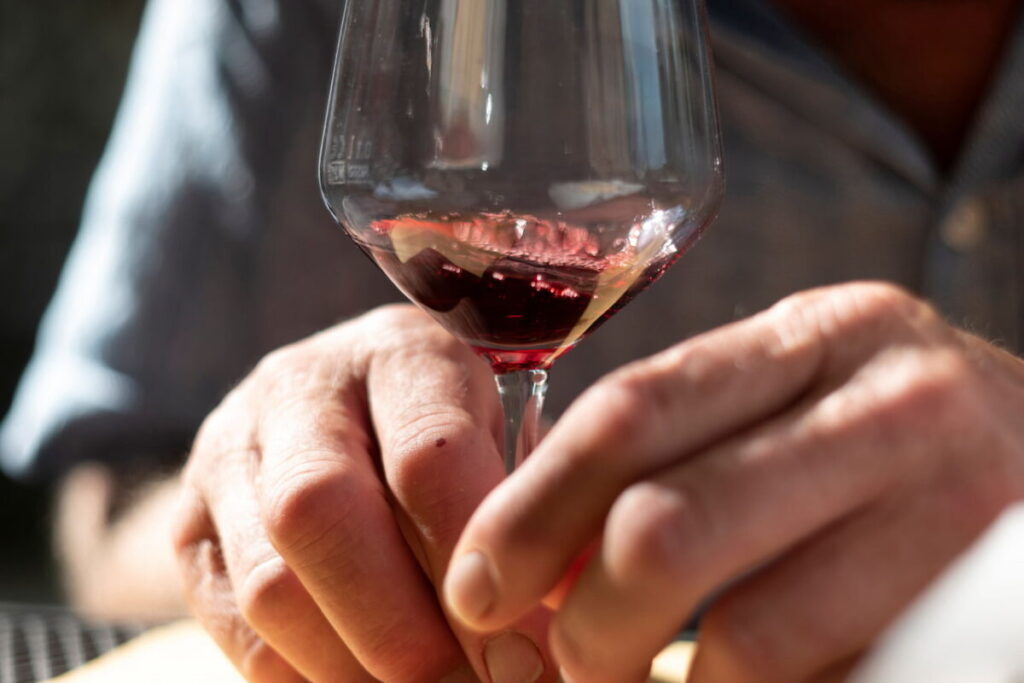 Close-up of a glass of Chianti red wine held by hand during a Florence market food tour