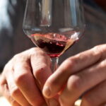 Close-up of a glass of Chianti red wine held by hand during a Florence market food tour