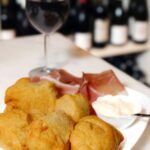 Fried dough with prosciutto and a glass of Chianti red wine at a Florence market food tour