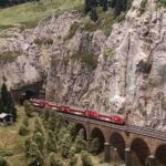 Miniature red train crossing a mountain viaduct at HZERO Museum Florence with kids