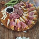 Tuscan charcuterie board with prosciutto salami melon and olives served at a farm family experience near Florence