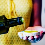 Extra virgin olive oil poured on Tuscan bread during an olive oil tasting tuscany experience included in a private wine tour from Florence.